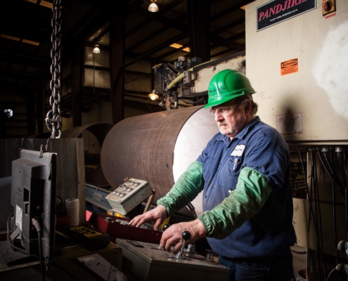 Side view of metal worker working on machine