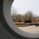 tractor carrying pipe through yard