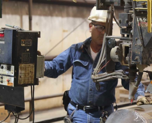 worker using machine to cut pipe