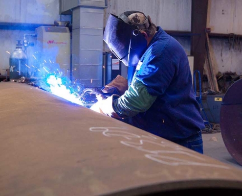 worker welding on large diameter pipe