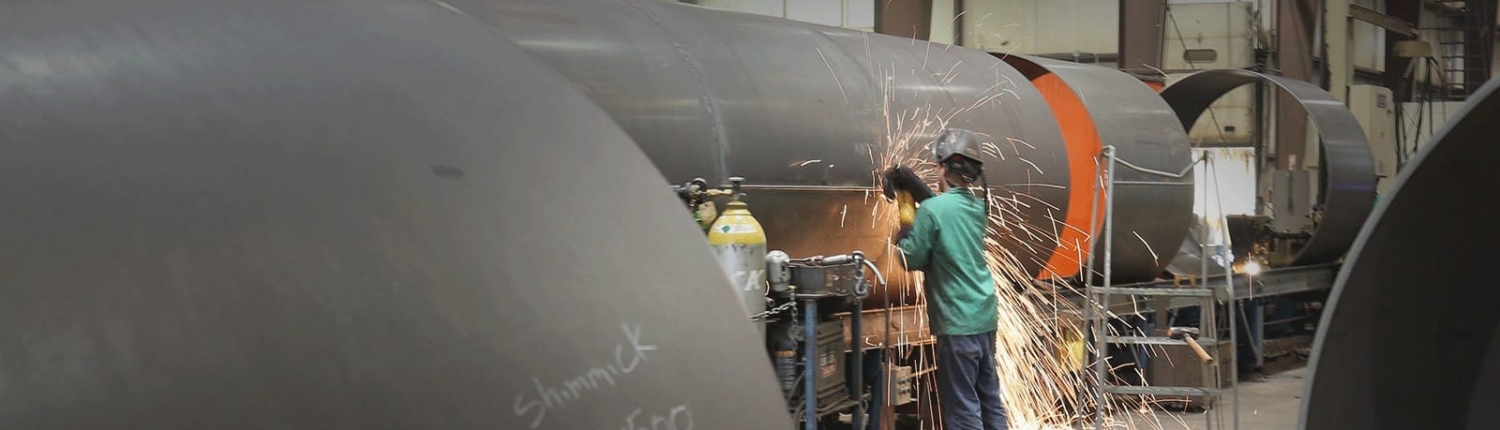 Worker using a cutting tool on a large diameter