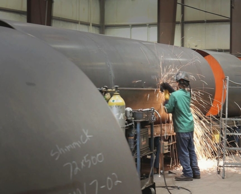 Worker using a cutting tool on a large diameter