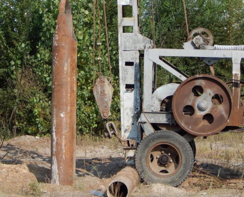 Water well rig installing water well casing pipe